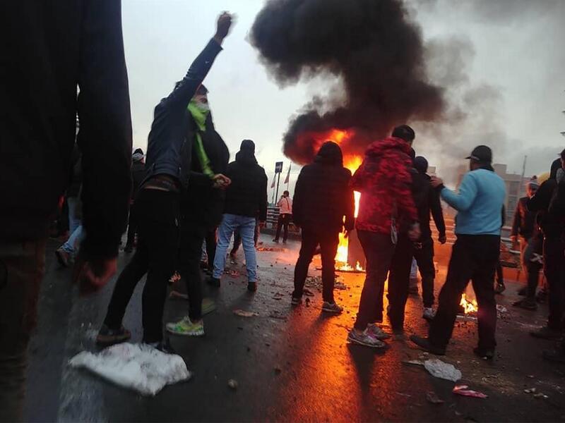 Iranian protesters gather around a fire during a demonstration against an increase in gasoline prices in the capital Tehran (AFP) Iranian protesters gather around a fire during a demonstration against an increase in gasoline prices in the capital Tehran (AFP)