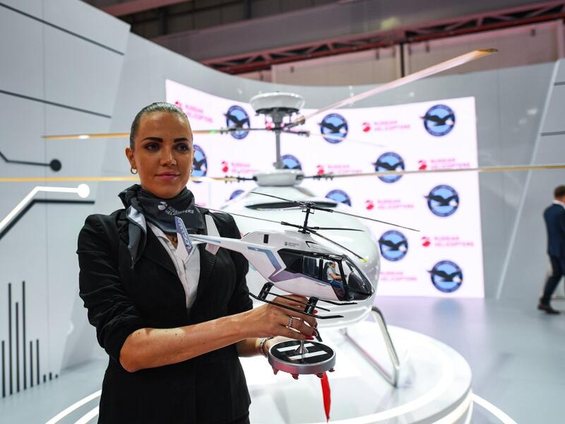 A Russian Helicopters presenter holds a model of a VRT 500 twin coaxial rotor light helicopter at a booth during the 2019 Dubai Airshow on November 18, 2019. KARIM SAHIB / AFP