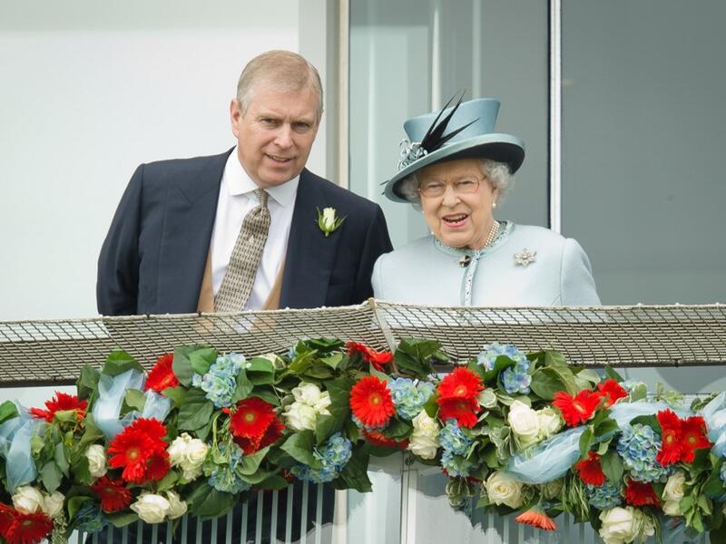 Prince Andrew, the Duke of York (L) speaks to Queen Elizabeth II on the Queens stand during Derby day at the Epsom Derby Festival, in Surrey, southern England, on June 1, 2013. (AFP/ File Photo)