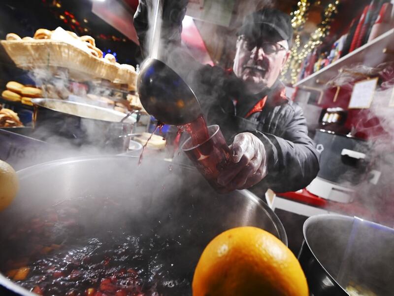 A stall tenant serves mulled wine at the traditional Christmas market in Strasbourg, eastern France, on November 23, 2019. FREDERICK FLORIN / AFP