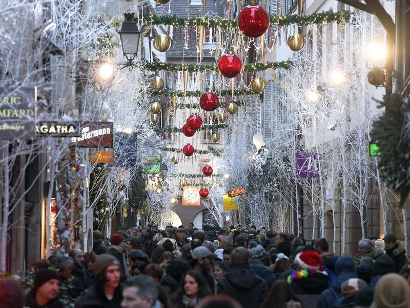 People walk under Christmas decorations during the traditional Christmas market in Strasbourg, eastern France, on November 23, 2019. FREDERICK FLORIN / AFP