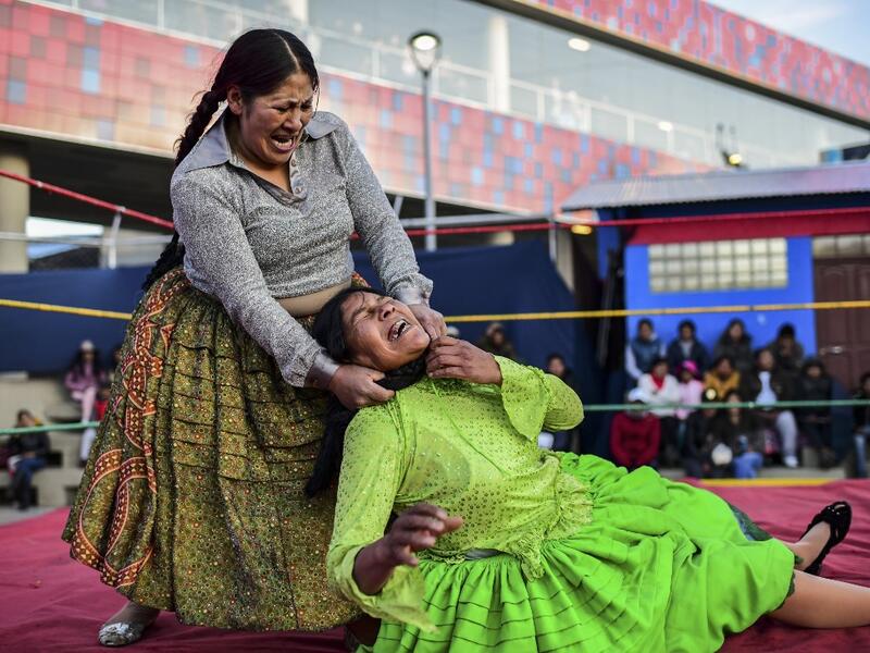 Bolivian wrestler Ana Luisa Yujra (L), aka "Jhenifer Two Faces" and Lidia Flores, aka "Dina, The Queen of the Ring", both members of the Fighting Cholitas, fight at Sharks of the Ring wrestling club in El Alto, Bolivia, on November 24, 2019. After a fortnight hiatus due to anti-government protests and blockades, the Fighting Cholitas are back in the ring. The unrest was triggered by the disputed October 20 election, which Evo Morales claimed to have won and opposition groups said was rigged. Ronaldo SCHEMID