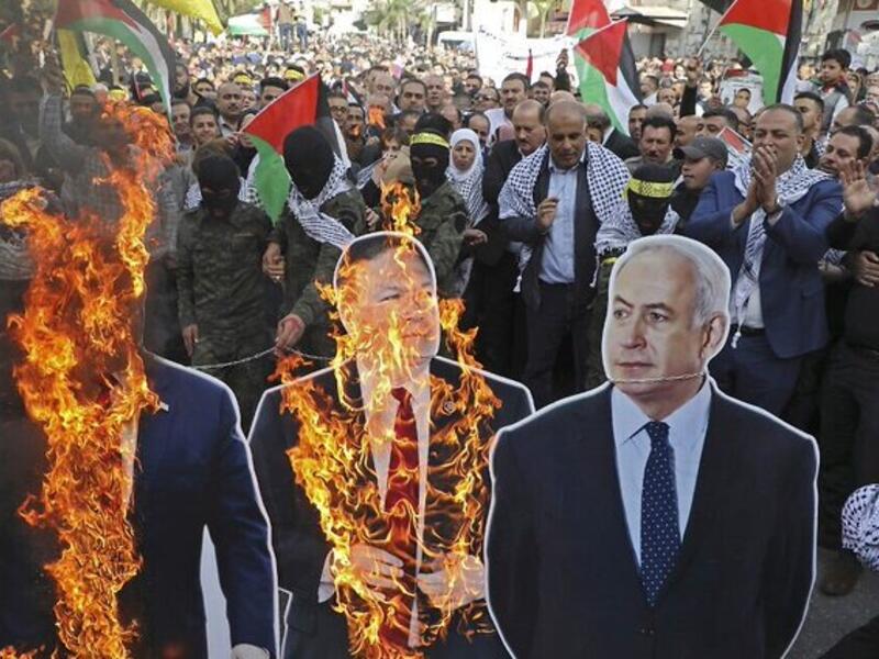 Palestinian protesters set an effigy of the US president afire on November 26, 2019 during a Palestinian "day of rage" against a recent US decision to no longer consider settlements in the West Bank illegal, in the West Bank city of Ramallah. A Palestinian convicted over the killing of three Israelis died of cancer in custody today, officials said.  ABBAS MOMANI / AFP
