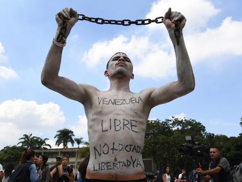 A university student holds a chain with his body painted during a protest against Venezuela's President Nicolas Maduro in Caracas on November 21, 2019. (Yuri CORTEZ / AFP)
