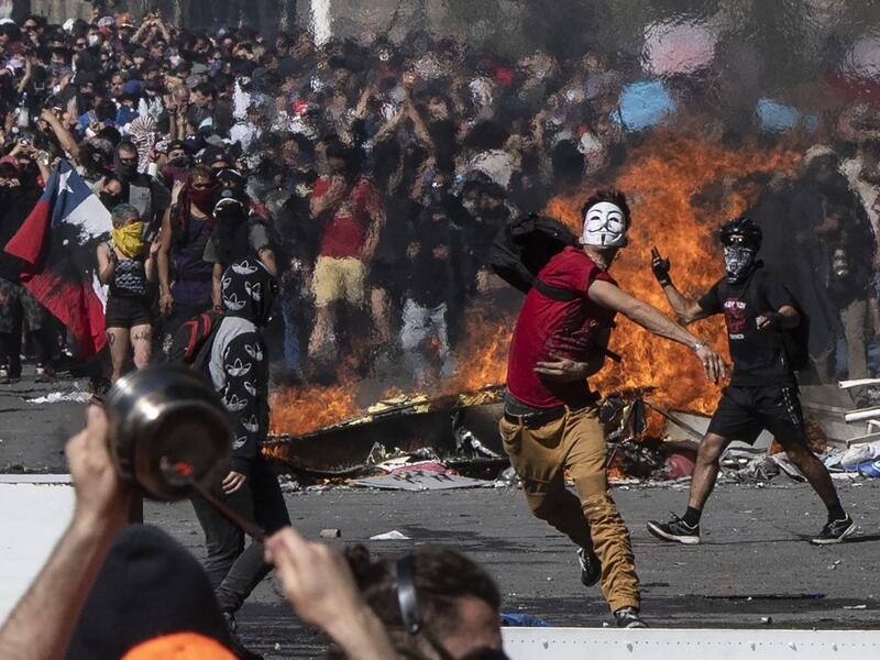People demonstrate at Plaza Italia on the fifth straight day of street violence which erupted over a now suspended hike in metro ticket prices, in Santiago on October 22, 2019. President Sebastian Pinera convened a meeting with leaders of Chile's political parties on Tuesday in the hope of finding a way to end street violence that has claimed 15 lives, as anti-government campaigners threatened new protests. Pedro UGARTE / AFP