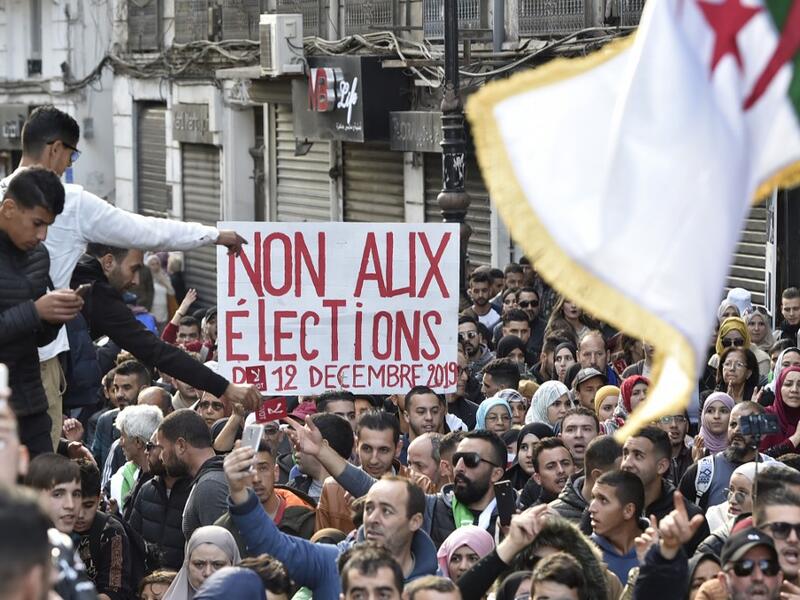 Algerian protesters shout slogans during an anti-government demonstration in the capital Algiers on December 10, 2019, ahead of the presidential vote scheduled for December 12. Algeria's contentious presidential election campaign is highlighting the vast gap between youth at the heart of a reformist protest movement and an ageing elite they see as clinging to power. RYAD KRAMDI / AFP