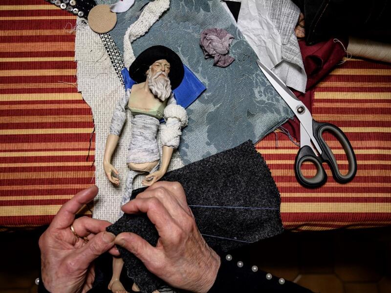 Volunteer Maria Franca Testa sews clothes for a nativity figure at the 43rd edition of the "Presepio of Cavallermaggiore", a 300sqm Christmas Nativity crib in the Oratorio San Michele on December 20, 2019 in Cavallermaggiore, near Cuneo, Northwestern Italy. The "presepio" is made by ten volunteers than every year spend 3 months to build a new edition with hundred of figures. MARCO BERTORELLO / AFP