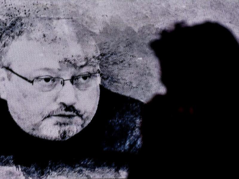 In this file photo taken on November 11, 2018 a man passes in front of a screen showing Jamal Khashoggi during a commemoration event of Khashoggi's supporters in Istanbul. Five people were sentenced to death on December 23, 2019, over Saudi journalist Jamal Khashoggi's murder, but two top aides to the powerful crown prince were exonerated as authorities said the killing was not premeditated. OZAN KOSE / AFP