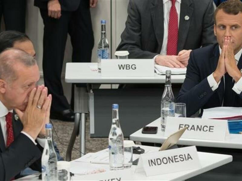 Turkey's President Recep Tayyip Erdogan (L) and his French counterpart Emmanuel Macron gesture as they attend a meeting on the digital economy at the G20 Summit in Osaka, Japan, June 28, 2019. (Photo by AFP)