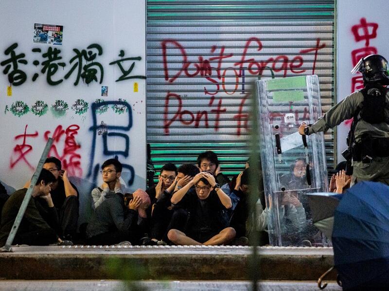Police detain a group of people after a pro-democracy march in Hong Kong on January 1, 2020. Tens of thousands of protesters marched in Hong Kong during a massive pro-democracy rally on New Year's Day, looking to carry the momentum of their movement into 2020.  ISAAC LAWRENCE / AFP