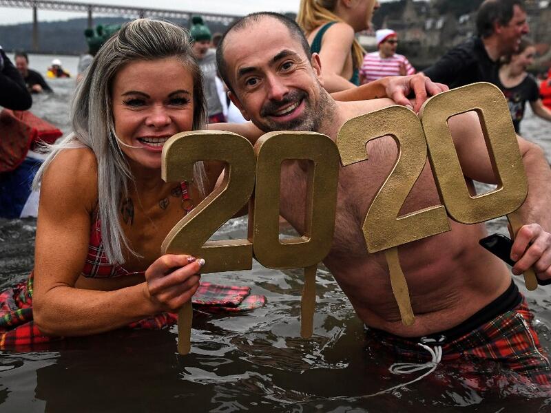Participants pose in the water as they take part in the annual New Year's Day "Loony Dook" swim, in the Firth of Forth, in South Queensferry, near Edinburgh, on January 1, 2020. Every year people brave the River Forth, near the Forth Bridge, on New Year's Day to see in the New Year and raise money for charity. ANDY BUCHANAN / AFP