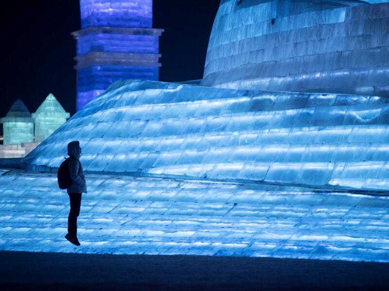 A tourist jumps in front of an ice sculpture during the Harbin International Ice and Snow Festival in Harbin, in China's northeast Heilongjiang province on January 5, 2020. Noel CELIS / AFP