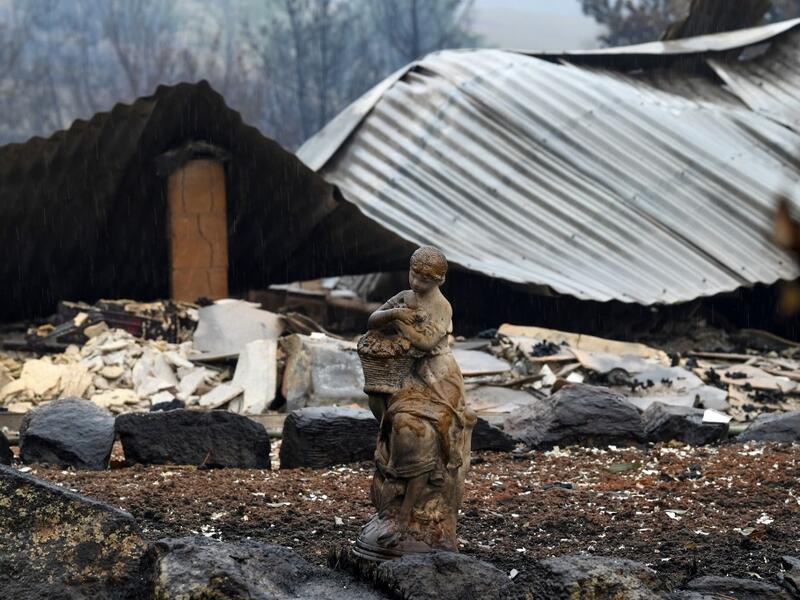 A statue at a burnt house is seen after an overnight bushfire in Quaama in Australia's New South Wales state on January 6, 2020. Reserve troops were deployed to fire-ravaged regions across three Australian states on January 6 after a torrid weekend that turned swathes of land into smouldering, blackened hellscapes. SAEED KHAN / AFP
