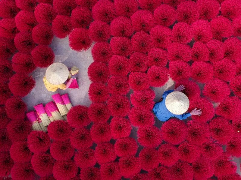 A Vietnamese woman collects dried incense sticks at a courtyard in Quang Phu Cau village on the outskirts of Hanoi on January 9, 2020 ahead of the upcoming Lunar New Year celebrations, referred to in Vietnam as Tet. Manan VATSYAYANA / AFP