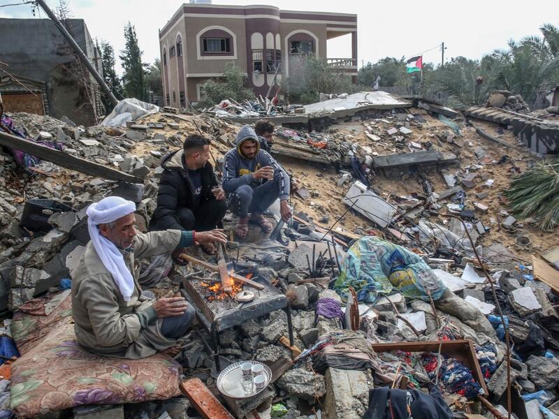 Palestinian Hammouda Abu Amra, 51, (L) sits with his sons on the site of his destroyed home in Khan Yunis in the southern Gaza Strip on January 10, 2020. Abu Amra, whose house was destroyed by an Israeli air strike last November, now lives in a shack with his family of seventeen. SAID KHATIB / AFP