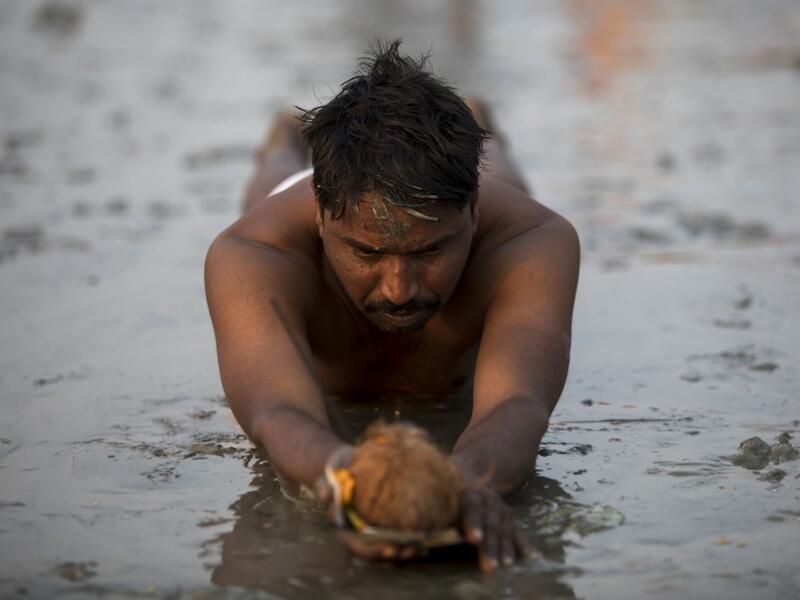 A Hindu devotee performs a ritual before taking a holy dip in the Bay of Bengal during the Gangasagar Mela, at Sagar Island, around 150 kms south of Kolkata on January 13, 2020. XAVIER GALIANA / AFP