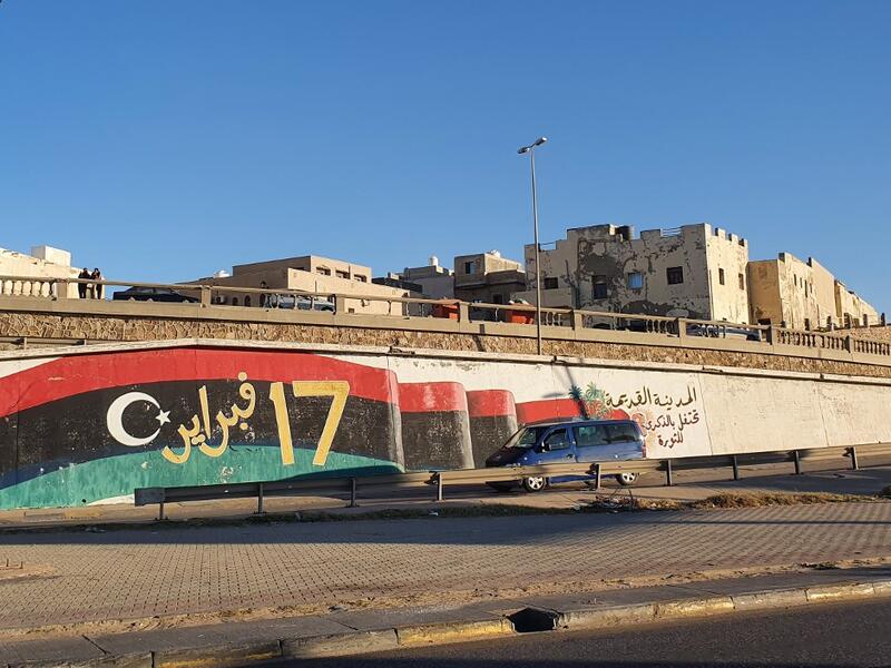 A vehicle passes by a mural inspired by the 2011 NATO-backed Libya uprising, in the Libyan capital Tripoli's old quarter, on January 20, 2020. A peaceful solution to Libya's protracted conflict remains uncertain despite an international agreement struck in Germany, analysts say, as a fragile ceasefire between warring factions brought only a temporary truce. Mahmud TURKIA / AFP