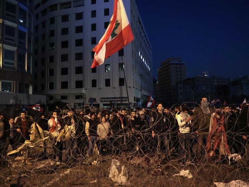 Lebanese anti-government demonstrators rally by barbed wire set by security forces to block a road leading to the government headquarters at the Grand Serail, in downtown Beirut, on January 25, 2020. ANWAR AMRO / AFP Lebanese anti-government demonstrators rally by barbed wire set by security forces to block a road leading to the government headquarters at the Grand Serail, in downtown Beirut, on January 25, 2020. ANWAR AMRO / AFP