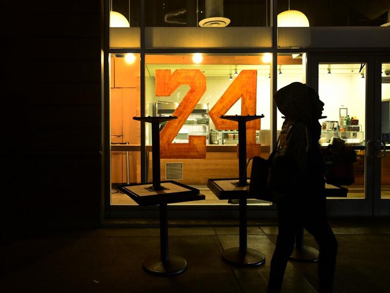 A person walks past a restaurant with "24" painted on the window as people mourn the death of NBA legend Kobe Bryant, who was killed along with his daughter and seven others in a helicopter crash on January 26, in Los Angeles on January 27, 2020. Federal investigators sifted through the wreckage of the helicopter crash that killed basketball legend Kobe Bryant and eight other people, hoping to find clues to what caused the accident that stunned the world. Frederic J. BROWN / AFP