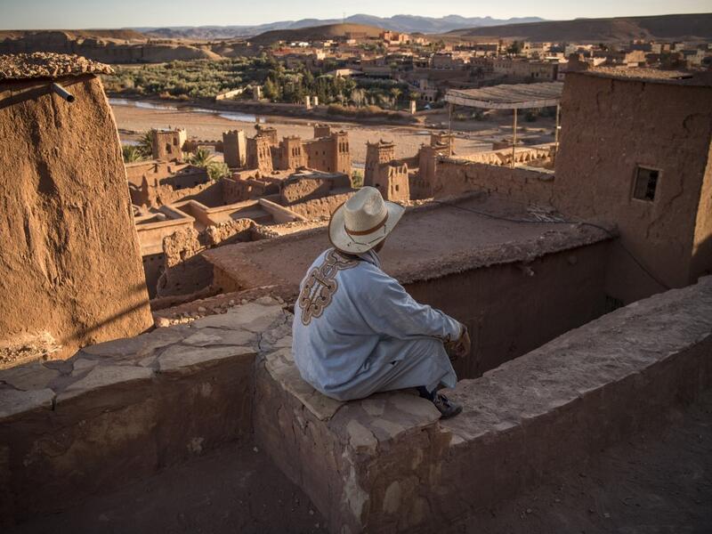 A man sits atop the Kasbah (ancient fortress) of Ait-Ben-Haddou, where scenes depicting the fictional city of Yunkai from the hit HBO television series "Game of Thrones" were filmed, about 32 kilometres northwest of the city of Ouarzazate south of Morocco's High Atlas mountains on January 27, 2020. FADEL SENNA / AFP