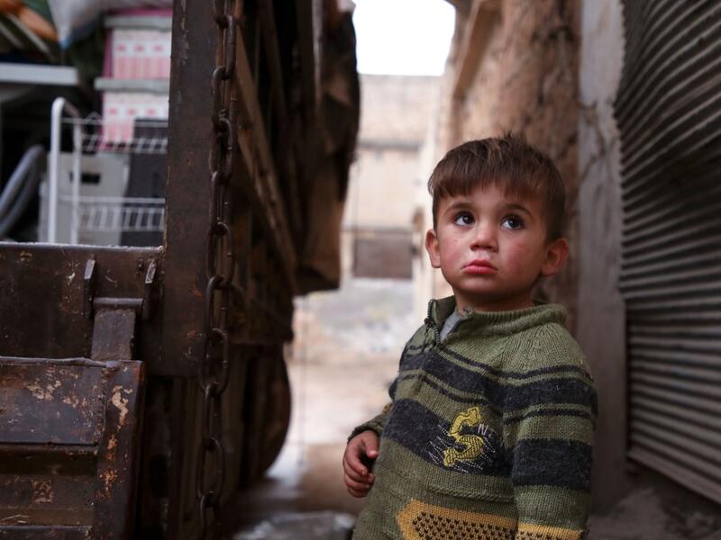 A Syrian child looks up as relatives load belongings onto a truck ahead of leaving the town of Binnish in the northwestern province of Idlib, on February 4, 2020, amid an ongoing offensive by pro-regime forces. A Russian-backed Syrian government offensive against the country's last rebel enclave of Idlib has displaced more than half a million people in two months, according to the United Nations. The wave of displacement, which coincides with a biting winter, is one of the largest since the start of the Syr