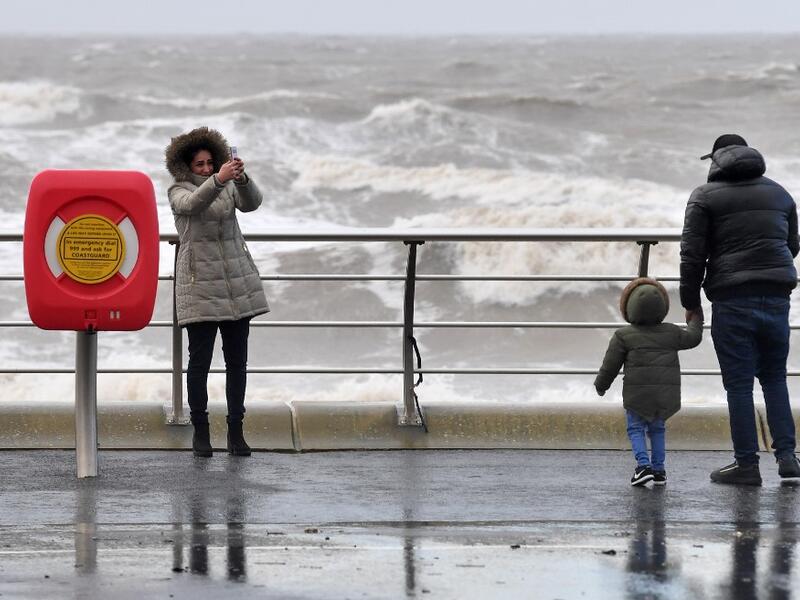 A woman takes a selfie photo with the stormy sea behind her in Blackpool, northwest England on February 9, 2020, as Storm Ciara swept over the country. Britain and Ireland hunkered down Sunday for a powerful storm expected to disrupt air, rail and sea links, cancel sports events, cut electrical power and damage property. With howling winds and driving rain, forecasters said Ciara would also hit France, Belgium, the Netherlands, Switzerland and Germany. Paul ELLIS / AFP