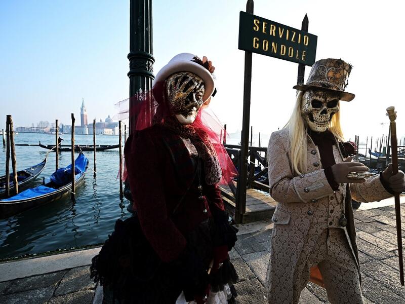 Masked revellers pose in Riva degli Schiavoni during the opening of the Venice Carnival on February 09, 2020. The carnival in Venice takes place until February 25, 2020. Vincenzo PINTO / AFP