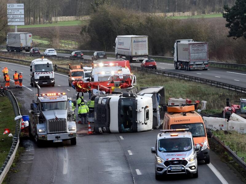 Rescuers work on the A2 motorway in Marly, northern France, after a truck was tipped over in the early morning from strong winds brought by storm Ciara on February 10, 2020. Hundreds of flights and train services were cancelled on February 10 as Storm Ciara sweeps over northwest Europe packing powerful winds, and leaving swatches of Europe without power after unleashing torrential rain and causing flash flooding. FRANCOIS LO PRESTI / AFP