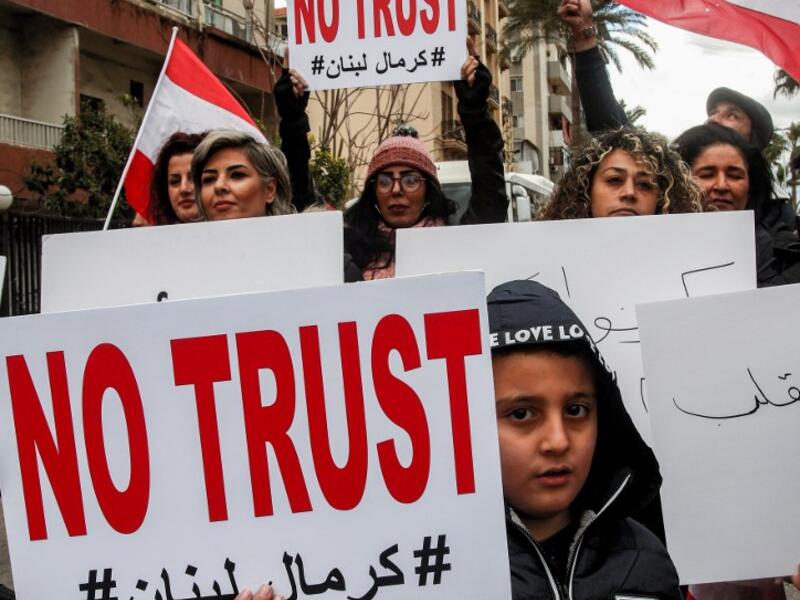 Anti-government demonstrators march with protest signs in the southern Lebanese city of Sidon on February 10, 2020, as they protest a day ahead of a parliamentary vote of confidence in the newly-formed government. Mahmoud ZAYYAT / AFP
