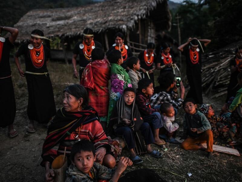 This photo taken on February 7, 2020 shows villagers watching the end of an overnight ceremony to bless the harvest by Naga tribeswomen in Satpalaw Shaung village, Lahe township in Myanmar's Sagaing region. A haunting refrain pierces the night as the tribeswomen of the Gongwang Bonyo, among the most isolated people in Myanmar, dance around a campfire to bless the harvest ahead. Ye Aung THU / AFP