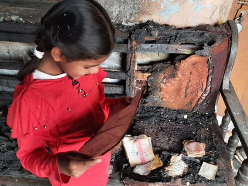 6 year old girl, Aaisha still finds her notebook to read from the debris of the house that was burnt in Monday violence in Chandbagh and Bhajanpura area of northeast Delhi. (Twitter)