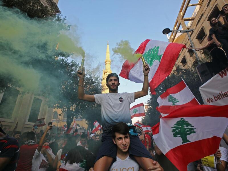 Lebanese protesters demand better living conditions and the removal of a cast of politicians who have monopolised power and influence for decades at Riad al-Solh Square in Beirut (AFP)