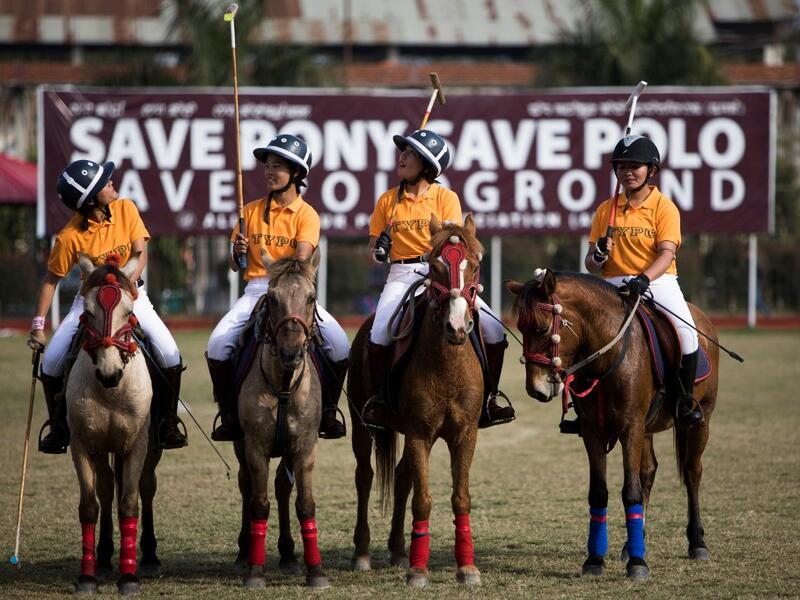 In this photograph taken on January 7, 2020, Thangmeiband Youth Polo Club players line up before their match against Linthoingambi Kangjei Lup polo club during the 15th Women's State Polo Tournament at the Mapal Kangjeibung (Polo Ground) in Imphal, the capital of the northeastern Indian state of Manipur. Laishram Thadoi's face is a picture of concentration as she adjusts her helmet and prepares to play in Manipur, the remote Indian state regarded as the birthplace of modern polo. Xavier GALIANA / AFP