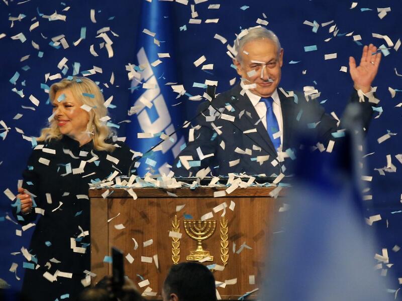 Israeli Prime Minister Benjamin Netanyahu and his wife Sara address supporters as confetti falls upon them at the Likud party campaign headquarters in the coastal city of Tel Aviv early on March 3, 2020, after polls officially closed. Netanyahu claimed "a giant victory" in elections on March 3, boasting that his right-wing Likud party had defied "all expectations" in the country's third vote in less than a year. After exit polls by three networks forecast that Likud and its allies were on track to win 59 pa