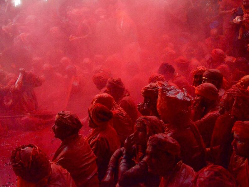 Coloured powder is thrown over villagers during the Lathmar Holi celebration in the village of Barsana on the outskirts of Mathura in the northern Indian state of Uttar Pradesh on March 4, 2020. Lathmar Holi is a local celebration of the Hindu festival of Holi, usually some days ahead of the Holi festival which is a spring festival, also called 'festival of colours' observed in India at the end of winter season. STR / AFP