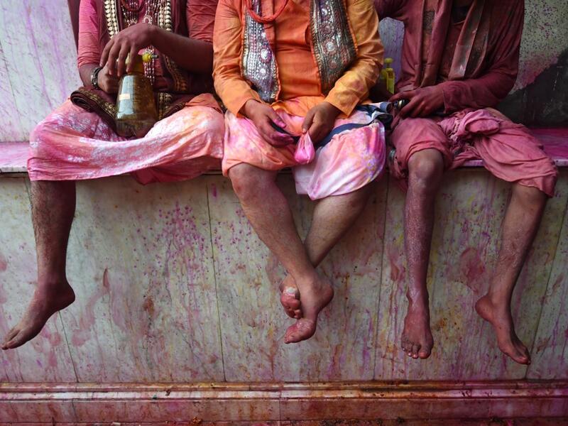 Hindu devotees sit in the column of a temple as they celebrate Holi, the spring festival of colours, during a traditional gathering at a temple in Nandgaon village in Uttar Pradesh state on March 5, 2020. Holi is observed in India at the end of the winter season on the last full moon of the lunar month. Money SHARMA / AFP