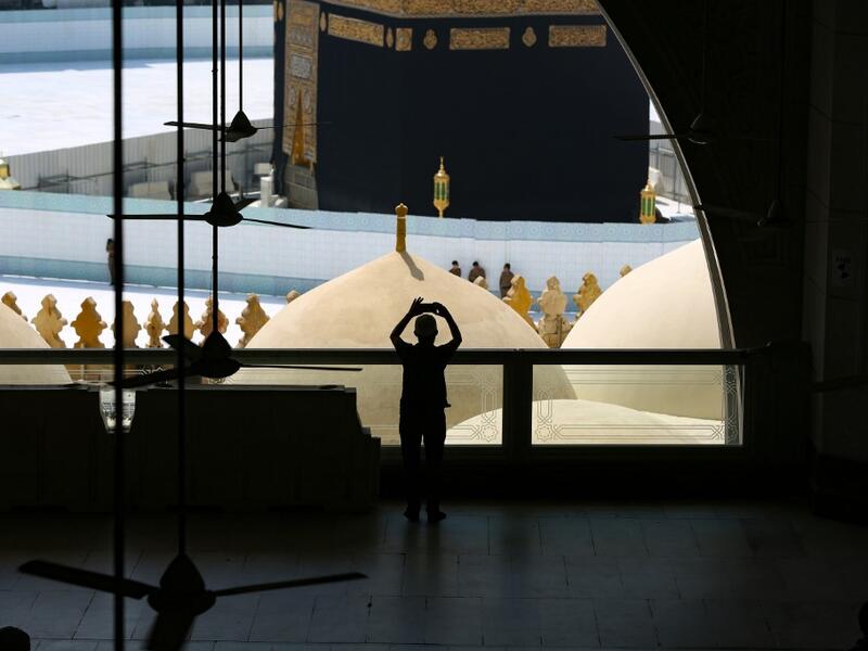 Worshippers take photographs of the Kaaba inside Mecca's Grand Mosque on March 6, 2020, a day after Saudi authorities emptied Islam's holiest site for sterilisation over fears of the new coronavirus COVID-19, an unprecedented move after the kingdom suspended the year-round umrah pilgrimage. Abdel Ghani BASHIR / AFP