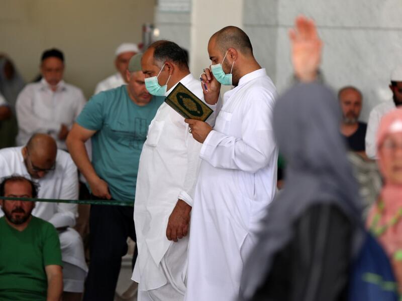 Worshippers, some of them wearing protective masks, take part in the Friday prayers in front of Mecca's Grand Mosque on March 6, 2020, a day after Saudi authorities emptied Islam's holiest site for sterilisation over fears of the new coronavirus COVID-19, an unprecedented move after the kingdom suspended the year-round umrah pilgrimage. Abdel Ghani BASHIR / AFP