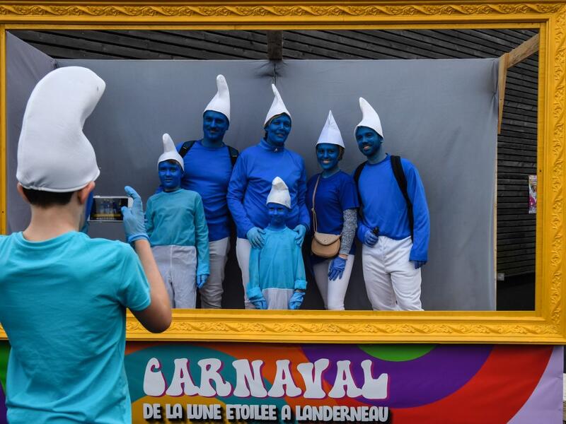 People dressed as Smurfs ('Schtroumpfs' in French), a Belgian comic franchise centered on a fictional colony of small, blue, human-like creatures who live in mushroom-shaped houses in the forest, pose for a picture during a world record gathering of Smurfs on March 7, 2020, in Landerneau, western France. Damien MEYER / AFP