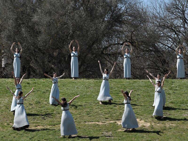 Women dressed as a priestesses take part in the Olympic flame lighting ceremony in ancient Olympia, ahead of Tokyo 2020 Olympic Games on March 12, 2020. LOUISA GOULIAMAKI / AFP