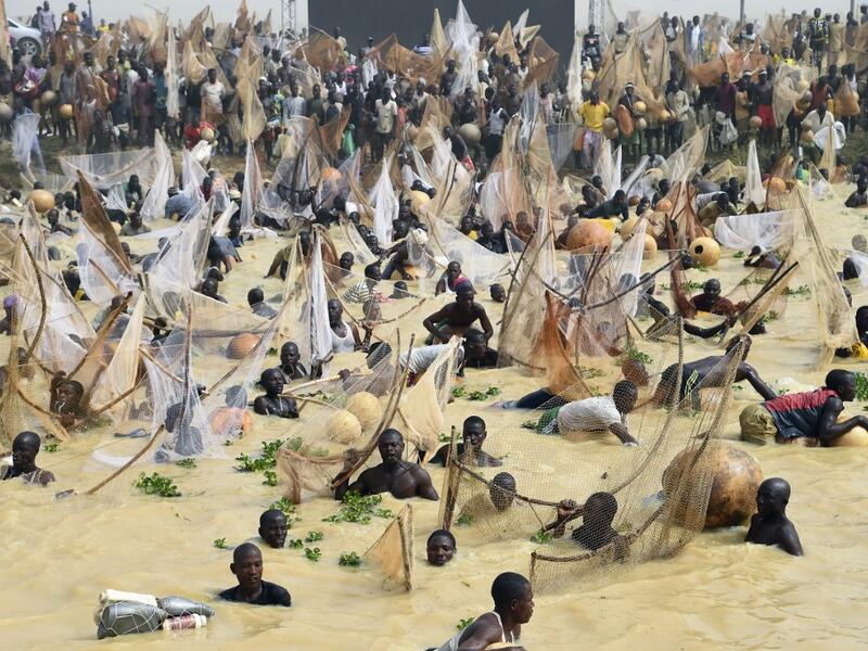 Fishermen try to catch fishes during the final of the revived Argungu fishing and cultural festival at Argungu Town, Kebbi State in northwest Nigeria, on March 14, 2020. Argungu fishing and cultural festival is one of the oldest and most widely attended festivals in the country dating back many generations, featuring series of water competitions and traditional games. The festival returned after 10 years suspension due to insecurity in northwest Nigeria. PIUS UTOMI EKPEI / AFP
