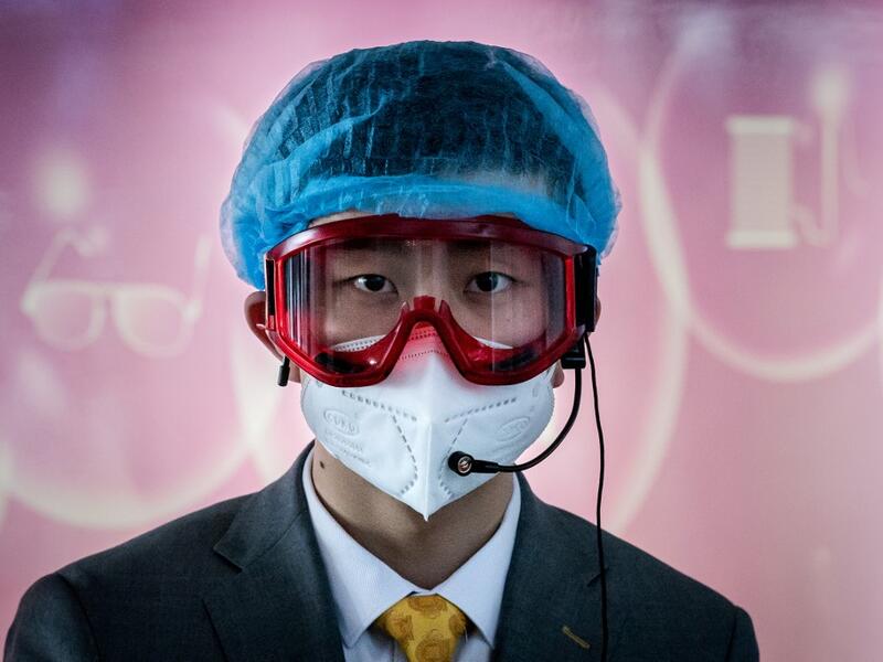 A worker at an information desk wearing protective gear as a preventive measure against the COVID-19 coronavirus looks on at a nearly empty arrivals area at Beijing Capital Airport in Beijing on March 16, 2020. China tightened quarantine measures for international arrivals as the country worries about a rise in imported cases of the deadly coronavirus and anger rages online at how Europe and the United States are handling the pandemic. NICOLAS ASFOURI / AFP