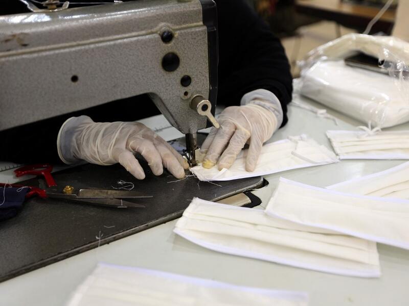 A Yemeni woman makes face masks at a textile factory in the capital Sanaa on March 16, 2020. More than a decade after it shut down, 20 women have brought back to life Yemen's oldest industrial factory to manufacture what could save many lives amid a global pandemic: masks. Mohammed HUWAIS / AFP