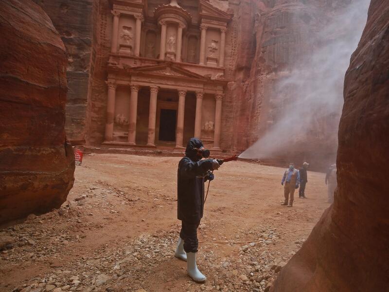 A labourer sprays disinfectant in Jordan's archaeological city of Petra south of the capital Amman on March 17, 2020, to prevent the spread of COVID-19. Khalil MAZRAAWI / afp