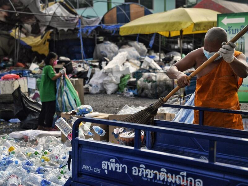 A Buddhist monk sorts salvaged plastic bottles to be recycled into monks’ robes and face masks, amid concerns over the spread of the COVID-19 coronavirus, at Wat Chak Daeng Buddhist temple in Samut Prakan on March 23, 2020. The plastic wastes are sent to a separate recycling facility processing it into thread materials and woven as special fabric for monks. Lillian SUWANRUMPHA / AFP