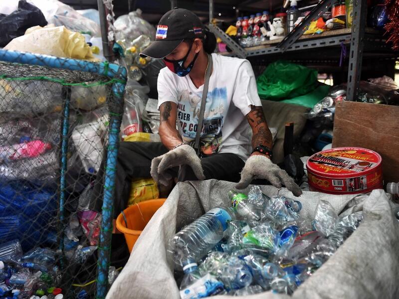 A Buddhist devotee sorts salvaged plastic bottles to be recycled into monks’ robes and face masks, amid concerns over the spread of the COVID-19 coronavirus, at Wat Chak Daeng Buddhist temple in Samut Prakan on March 23, 2020. The plastic wastes are sent to a separate recycling facility processing it into thread materials and woven as special fabric for monks. Lillian SUWANRUMPHA / AFP