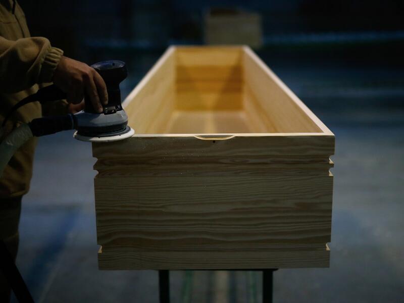 An employee polishes a coffin at the Eurocoffin coffins factory in Barcelona on April 3, 2020. More than 900 people died in Spain over the past 24 hours for the second day running, government figures showed, although the rate of new infections and deaths continued to slow. Spain has the world's second-highest death toll after Italy with the virus so far claiming 10,935 lives from 117,710 confirmed cases.  PAU BARRENA / AFP