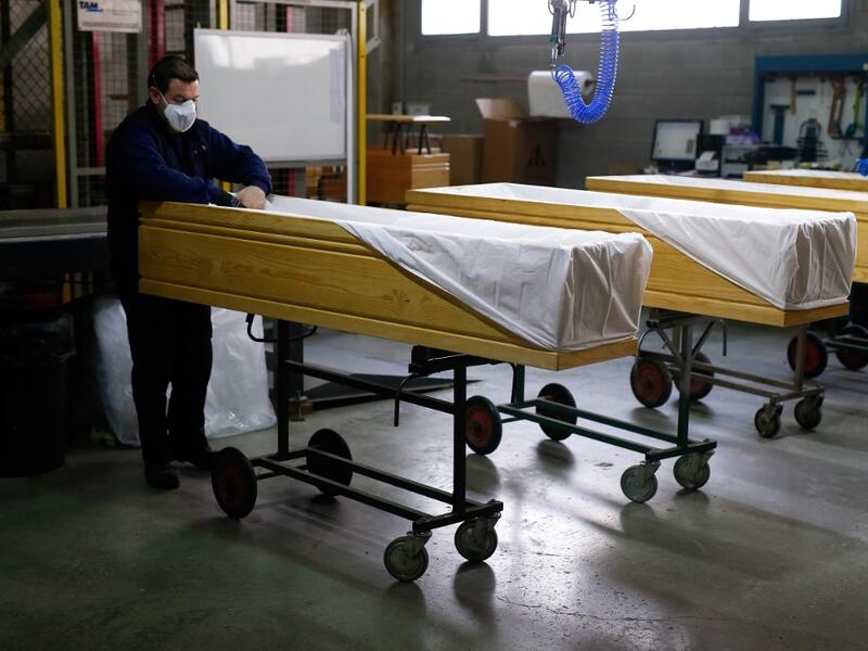 An employee covers coffins at the Eurocoffin coffins factory in Barcelona on April 3, 2020. More than 900 people died in Spain over the past 24 hours for the second day running, government figures showed, although the rate of new infections and deaths continued to slow. Spain has the world's second-highest death toll after Italy with the virus so far claiming 10,935 lives from 117,710 confirmed cases.  PAU BARRENA / AFP