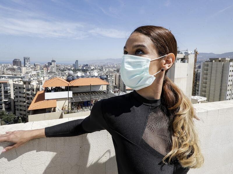 Sherazade Mami, a 28-year-old Tunisian professional dancer and performer at the Caracalla dance theatre and a teacher at the Caracalla dance school, practices while wearing a surgical mask on the roof of her apartment building in the suburb of Dekwaneh on the eastern outskirts of Lebanon's capital Beirut on April 4, 2020. Due to the confinement regulations imposed to combat the COVID-19 coronavirus pandemic, Mami opted to continue practicing on her rooftop to remain in shape. JOSEPH EID / AFP