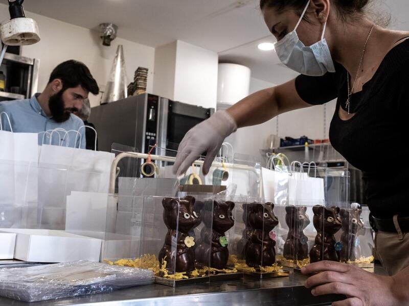Employees of pastry and chocolate maker Didier Girard prepare Easter chocolates before delivering them at clients' homes in Vourles, near Lyon at on April 7, 2020, on the twenty-second day of a strict lockdown in France to stop the spread of COVID-19, caused by the novel coronavirus. JEAN-PHILIPPE KSIAZEK / AFP